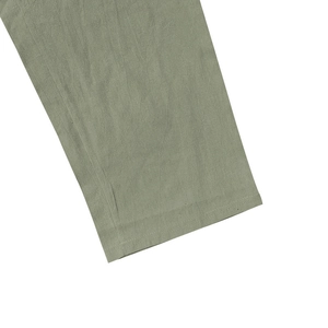 Dettaglio dell'orlo dei pantaloni da spiaggia in lino da uomo con cuciture verde salvia