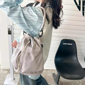 Fashionable light gray nylon bucket bag with drawstring closure and wide strap