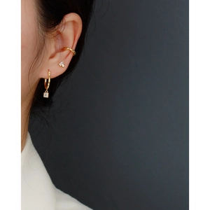 Detailed view of gold irregular earrings with rhinestones on a model in close-up