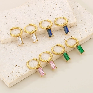 Détail macro de boucles d'oreilles rectangle en zircon de quatre couleurs sur pierre