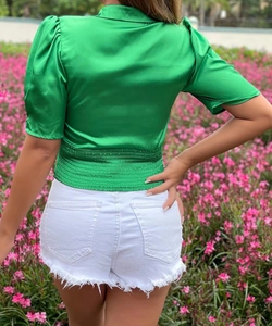 Back view of a green satin puff sleeve crop top with a cinched waist design
