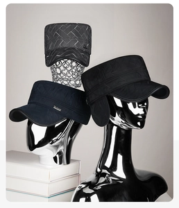Detail of winter quilted flat top hats with ear flaps in grey, navy, and black colors