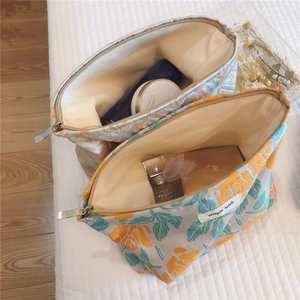 Macro detail of floral fabric cosmetic bags showing spacious interior and metal zipper