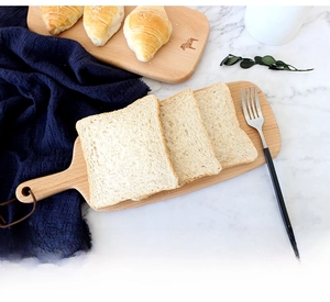 Japanese beech wood bread board with handle and leather hanging rope on marble surface