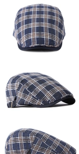 Tres vistas de una gorra plana azul marino con diseño de cuadros y hebillas metálicas laterales