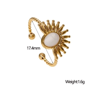 Détail macro d'une bague dorée avec pierre blanche ovale et anneau torsadé vintage