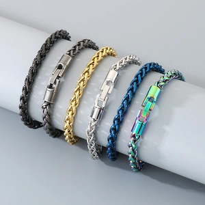 Détails de divers bracelets tressés en acier inoxydable coloré sur un présentoir