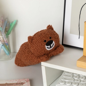 Close-up of cute brown teddy bear plush pencil case with soft lamb wool texture on a desk