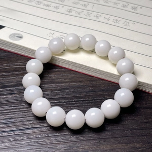 Detailed close-up of white bodhi root beads with smooth texture on dark wooden desk