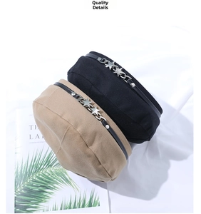 Close-up of black and khaki berets featuring decorative silver star chains and rivets
