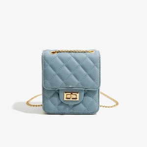 Detailed close-up of blue quilted PU leather bag with golden chain and twist lock