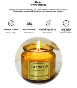 Close-up of a lit amber glass scented candle featuring a golden handmade label