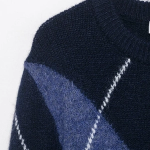 Navy blue crew neck knit sweater with light blue diamond argyle pattern and fuzzy texture