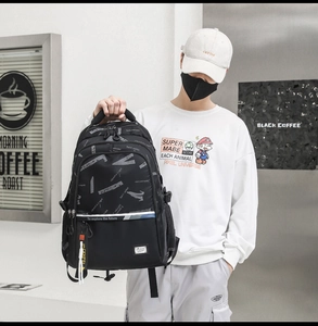Close-up of black multi-compartment backpack with geometric letter print and zipper details