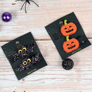 Halloween hair clips set featuring black glitter bats and orange felt pumpkins on wood
