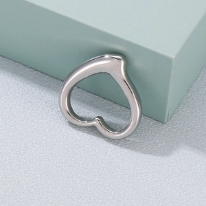 Polished silver stainless steel heart pendant on a minimalist light grey textured surface