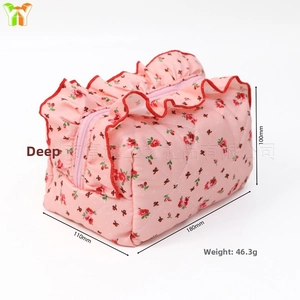 Dettaglio macro della borsa da trucco floreale con bordo in pizzo e trama trapuntata