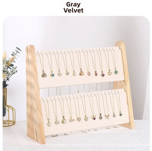 Detail of two-tier grey velvet jewelry stand with natural wood frame for necklaces