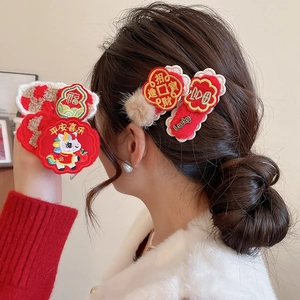 Detailed view of Chinese New Year red hair clips with traditional embroidery and pearls