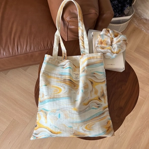 Abstract wood grain ink print cotton tote bag and matching scrunchie on coffee table