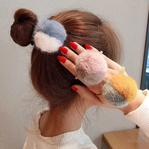 Dettaglio di elastici per capelli in peluche bicolore su modella con texture soffice e stile