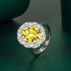 Macro shot of oval yellow gemstone ring with adjustable silver band and diamond halo