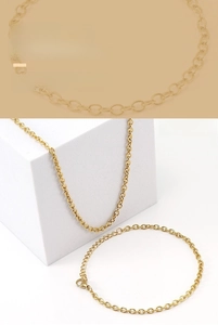 Macro detail of golden stainless steel rollo chain necklace and bracelet jewelry set