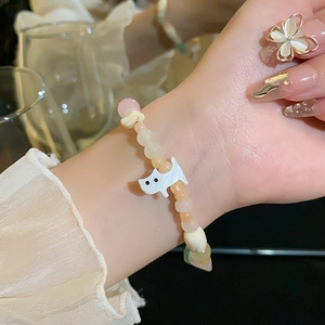 Détail du bracelet en perles avec breloque chien blanc et couleurs pastel style macaron