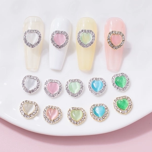Macro detail of heart cat eye nail charms with sparkling rhinestones in various colors