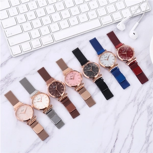 Detail view of seven quartz watches with magnetic Milanese straps on a marble table