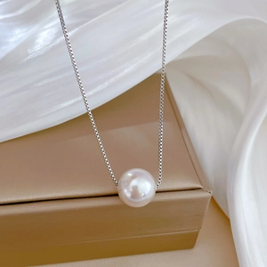 Minimalist titanium steel pearl necklace with box chain over elegant silk background
