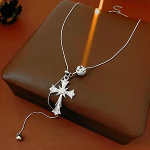 Tiger eye silver cross pendant necklace with sparkling crystals on premium leather background