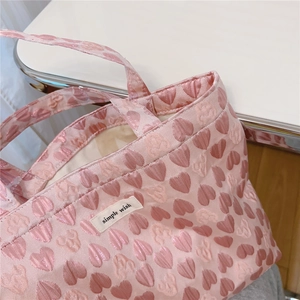 Detail of pink heart jacquard fabric tote bag with a simple wish rectangular label