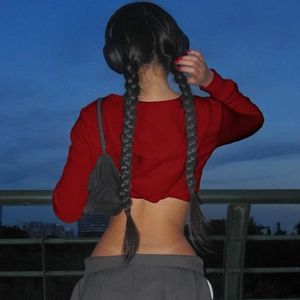 Vista trasera de una sudadera roja corta con capucha y cremallera en un entorno nocturno