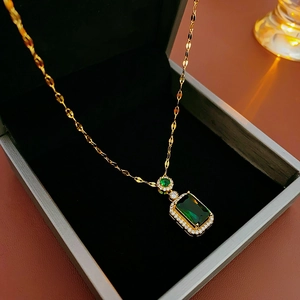 Macro shot of a vintage emerald green rectangular necklace with a golden chain in a gift box