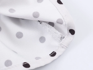 Detail shot of black polka dot print fabric with neat stitching and woven texture