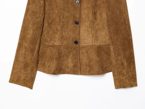Close-up of brown suede jacket hem and sleeve showing high-quality black button detail