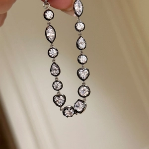 Macro detail of multi-shape cubic zirconia chain with heart and teardrop cut stones