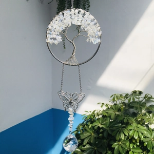 Detail of silver wire-wrapped tree of life pendant with white stones and crystal ball