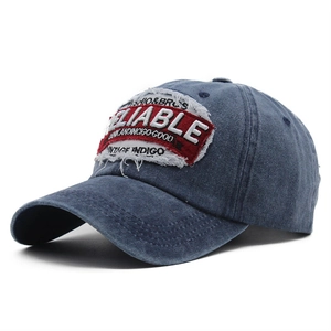 Detail of vintage navy blue washed cotton baseball cap with red reliable patch embroidery
