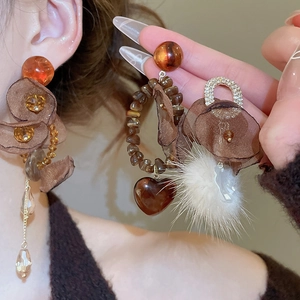 Detail of vintage mesh flower earrings with amber beads and soft faux fur pom-poms