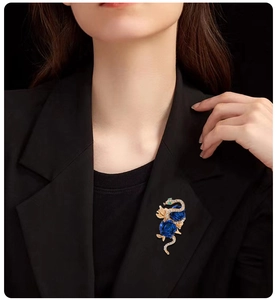 Close-up of golden snake brooch with blue enamel roses pinned on a black suit lapel