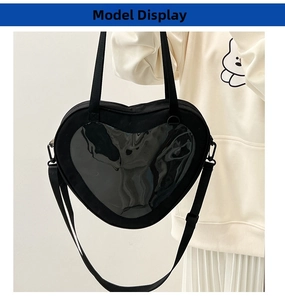 Detail of black heart-shaped crossbody bag with transparent PVC window for badges