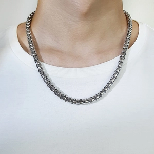 Gros plan d'un collier chaîne box en acier titane argenté porté par un mannequin