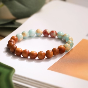 Detail of natural wood and agate bead bracelet on white book background with soft lighting