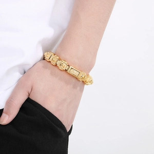 Close-up of vintage gold skull link bracelet with relief patterns on male model wrist