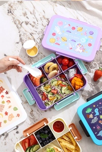 Detail view of colorful multi-compartment bento boxes with cute cartoon prints and forks