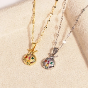 Close-up of gold and silver ladybug necklaces with colorful crystals on beige velvet