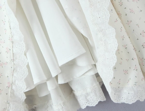 Gros plan du tissu floral avec bordure en dentelle blanche et broderie sur l'ourlet