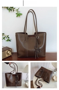 Detail view of coffee brown tote bag with white contrast stitching and cat charm detail